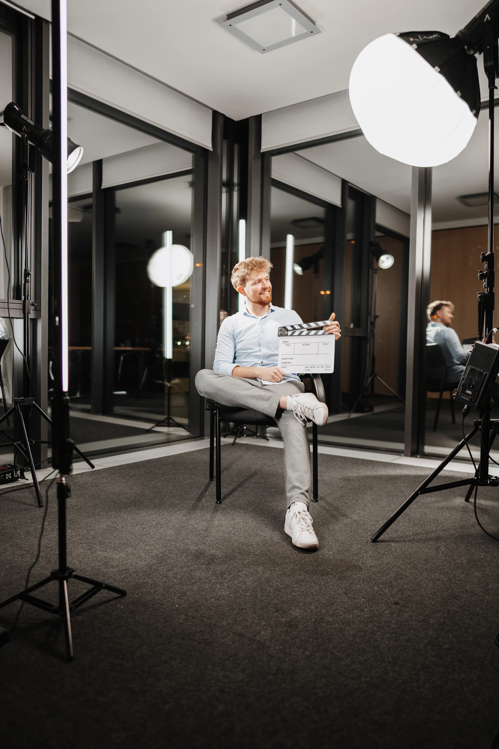 Sitzender Mann mit Filmklappe – EMC Studios