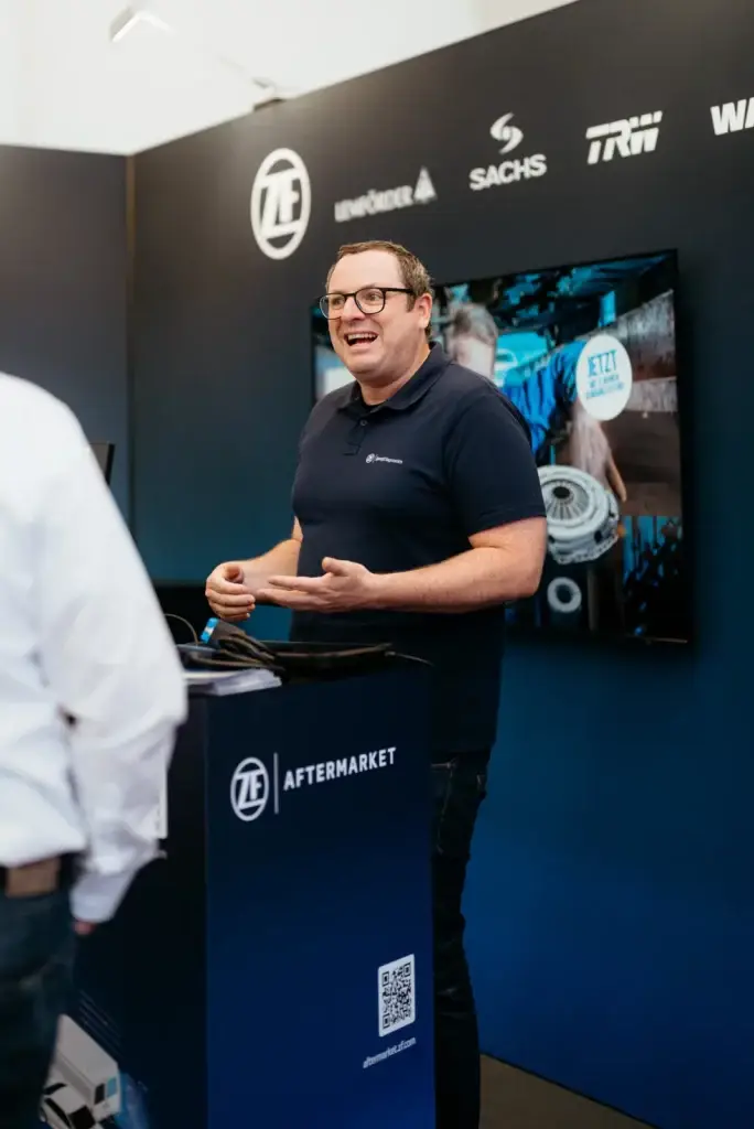 Lachender ZF Mitarbeiter im Gespräch am Messestand